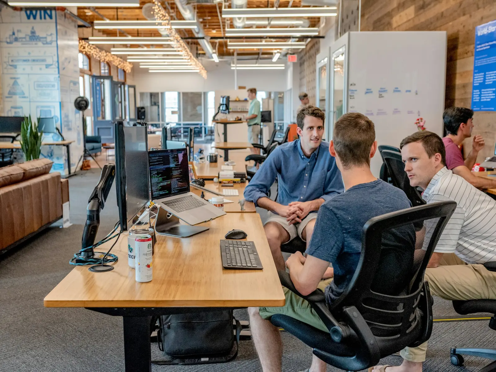 A team talking together at their desks in an open-plan office