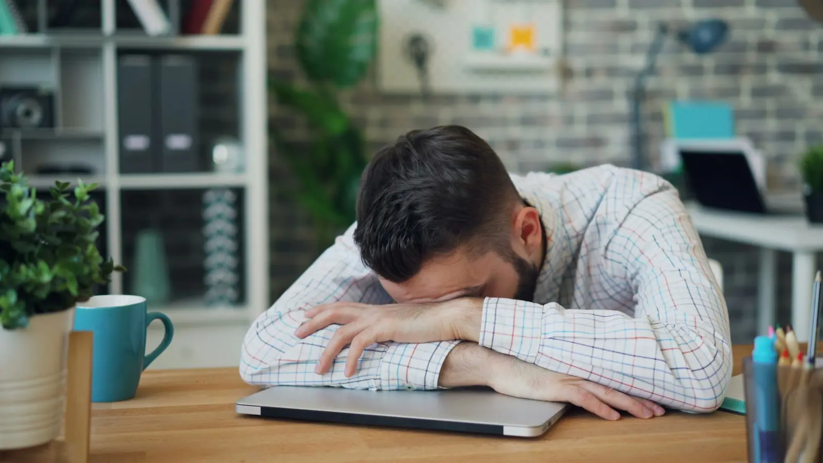 A man at his desk with his head in his hands
