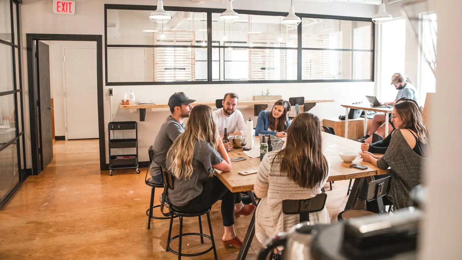 A team working together at long tables in an open-plan studio