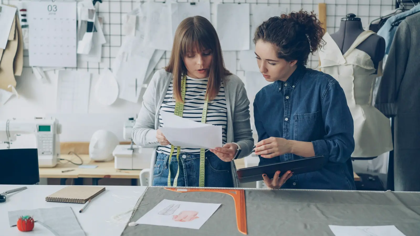 Two fashion designers reviewing work together in a studio