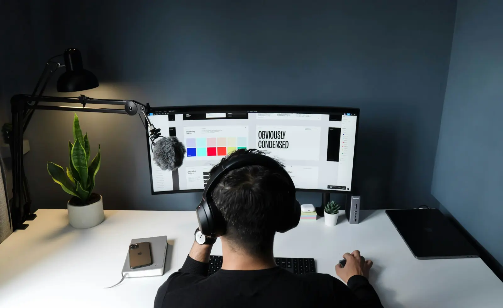 A designer in headphones working at a desktop monitor